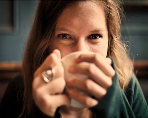 Mature woman relaxing with a cup of tea by the window